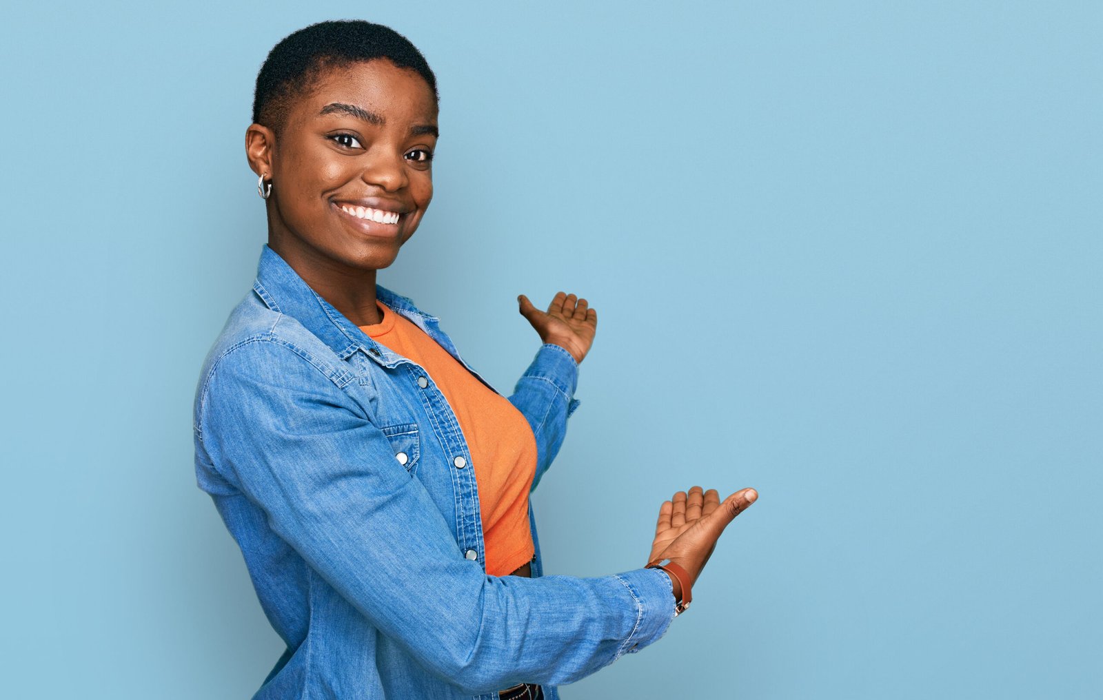 young african american woman wearing casual clothes inviting to enter smiling natural with open hand